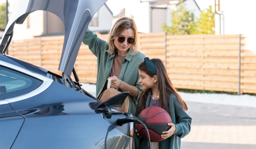 Mother and Daughter Loading Up An Electric Vehicle While It Is Charging